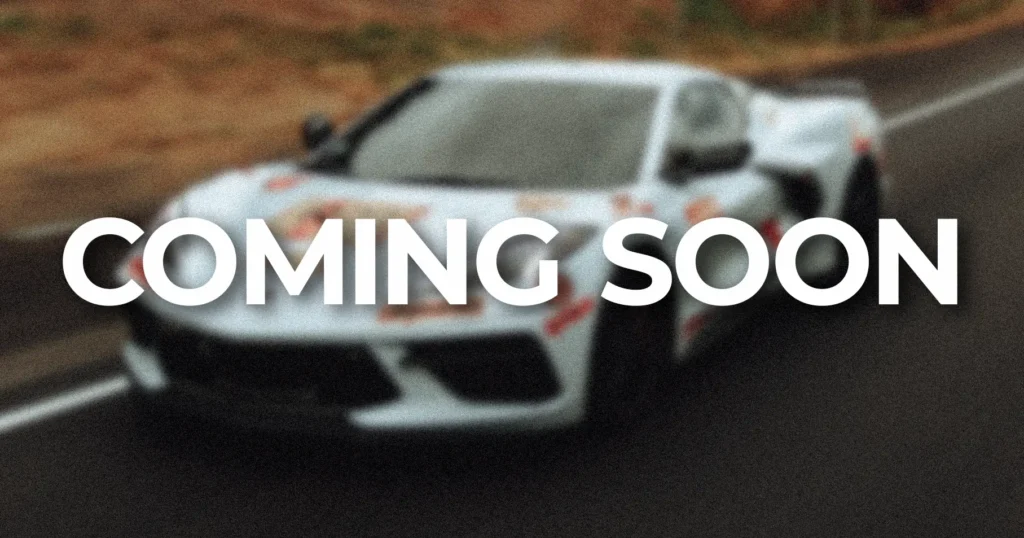 a white sports car on the road with words coming soon.