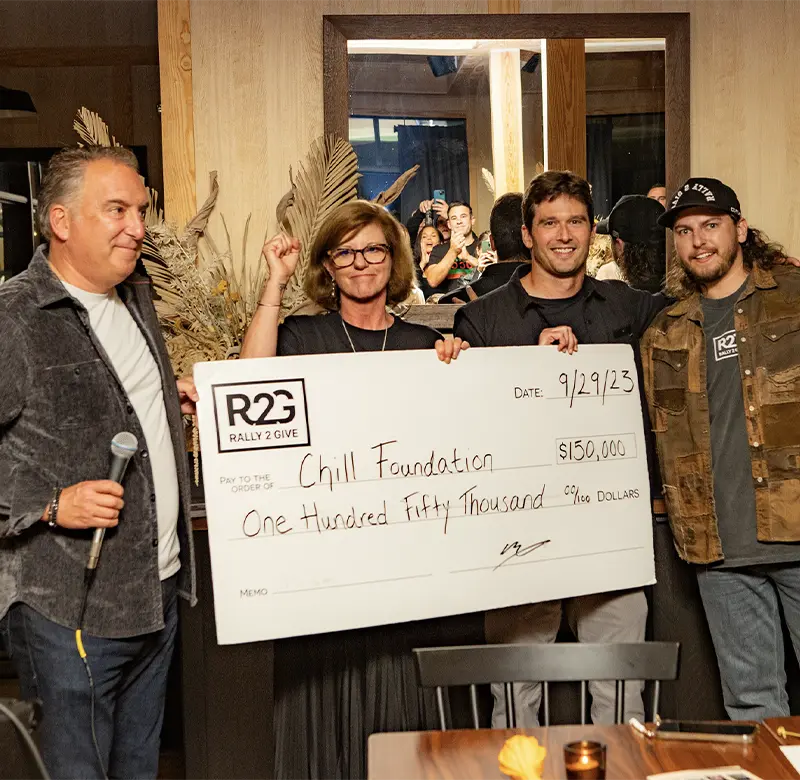 Rally 2 Give founders Rick and Matt St. Jean present a $150,000 donation check to Chill Foundation representatives during the 2023 fundraising event.